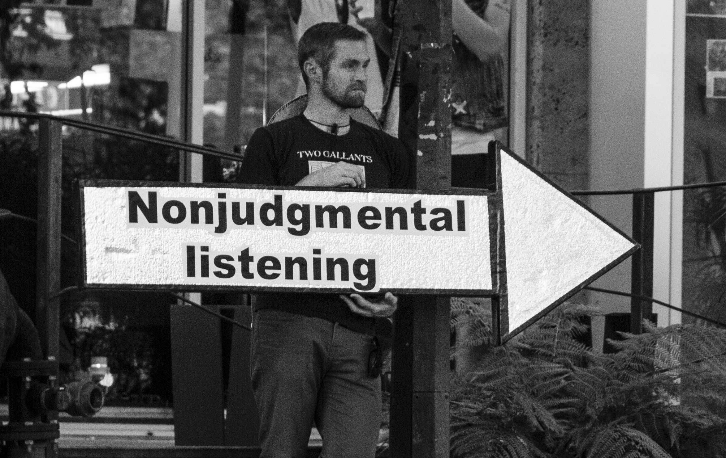 man with sign "Nonjudgmental listening