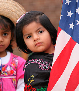 Hispanic girl holding American flag.