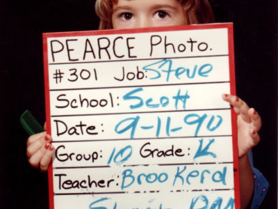 Kindergarten girl holding photographer's sign for class photo