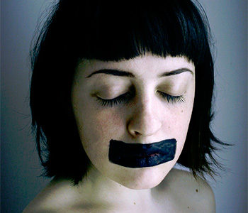 young woman with black tape over her mouth