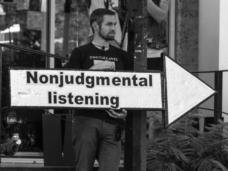 man with sign "Nonjudgmental listening