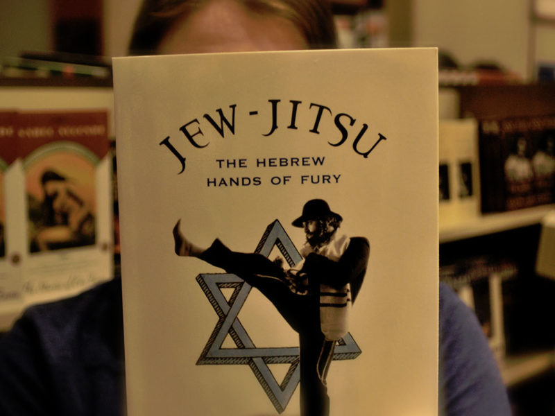 Person holding book called "Jew-Jitsu."