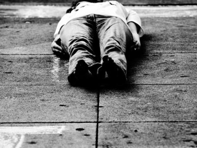 person laying on pavement in protest