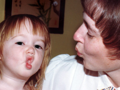 woman teaching child to pucker for a kiss