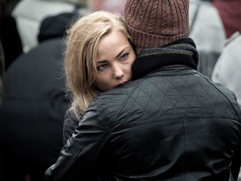woman hugging man on street