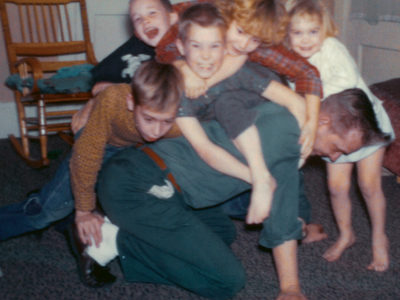 man wrestling his 5 children
