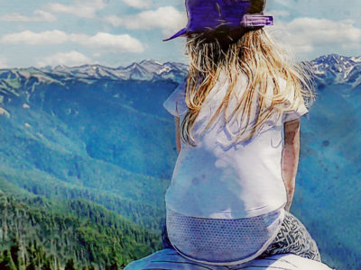 girl on father's shoulders looking at mountains